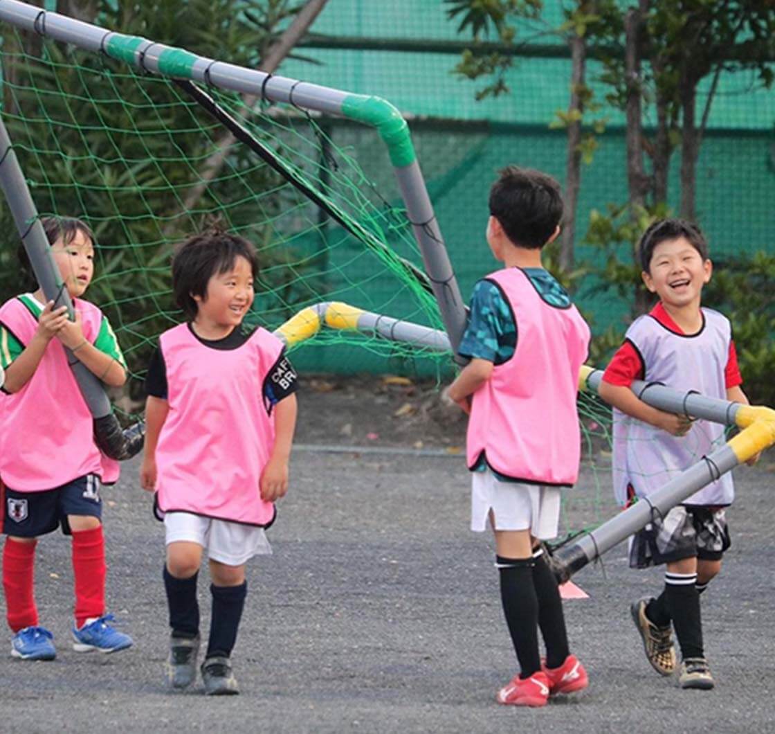 ゴールを運びながら楽しそうに会話する子供たち