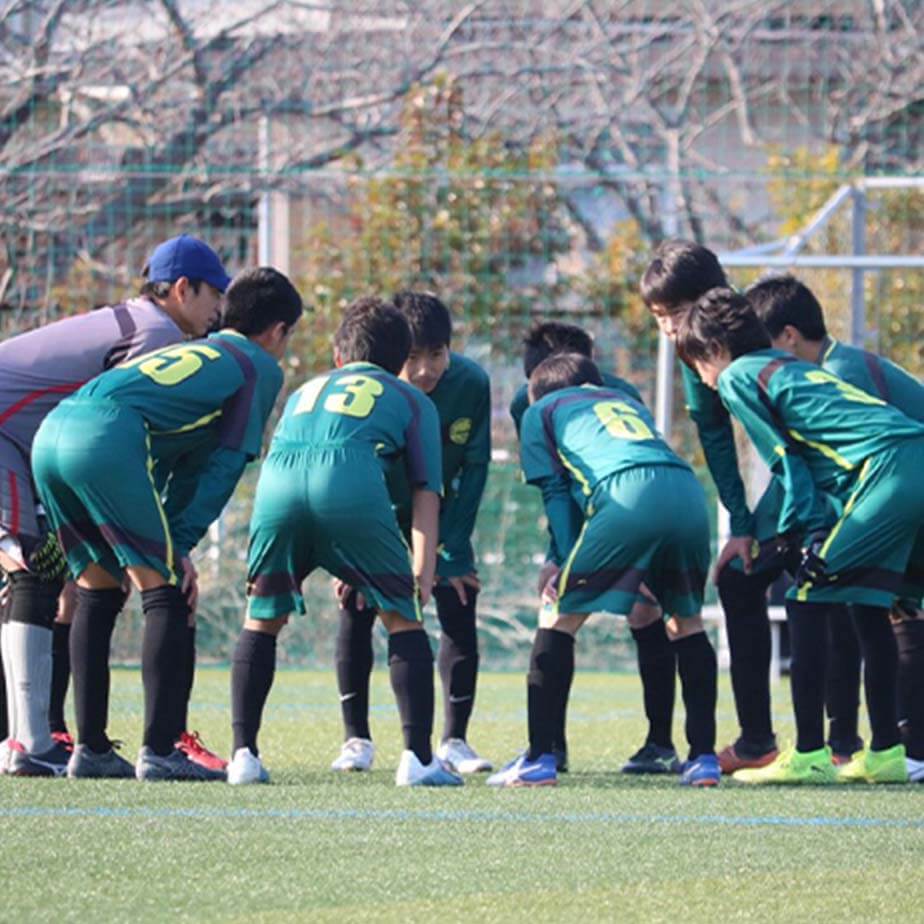 中学生のジョガドール静岡の選手たちが、コート上で円になって話し合っている写真